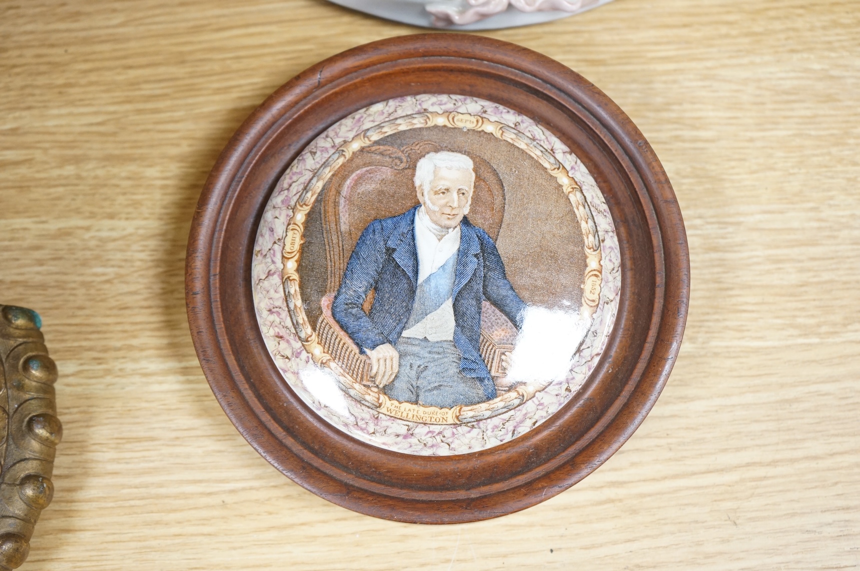A Duke of Wellington pot lid, another Prattware pot lid and a German floral encrusted porcelain mirror, largest 33cm high